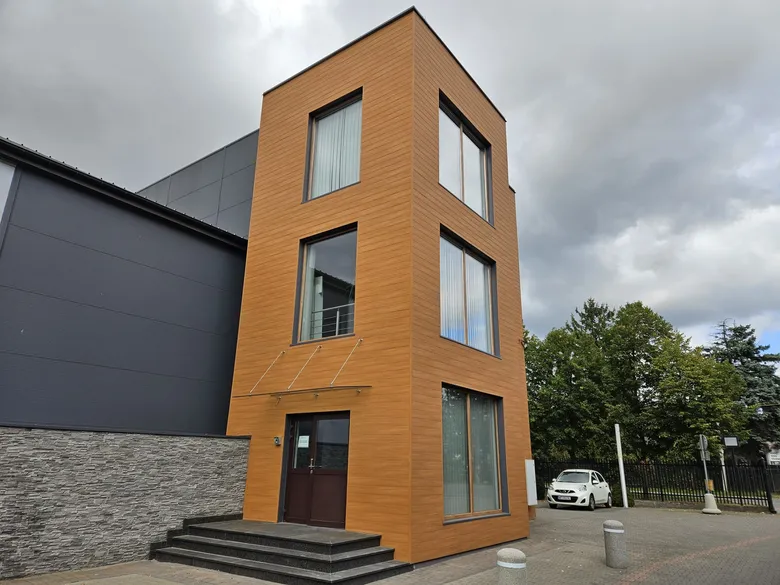 Budynek biurowy z klatką schodową obłożoną panelami aluminiowymi w dekorze drewna