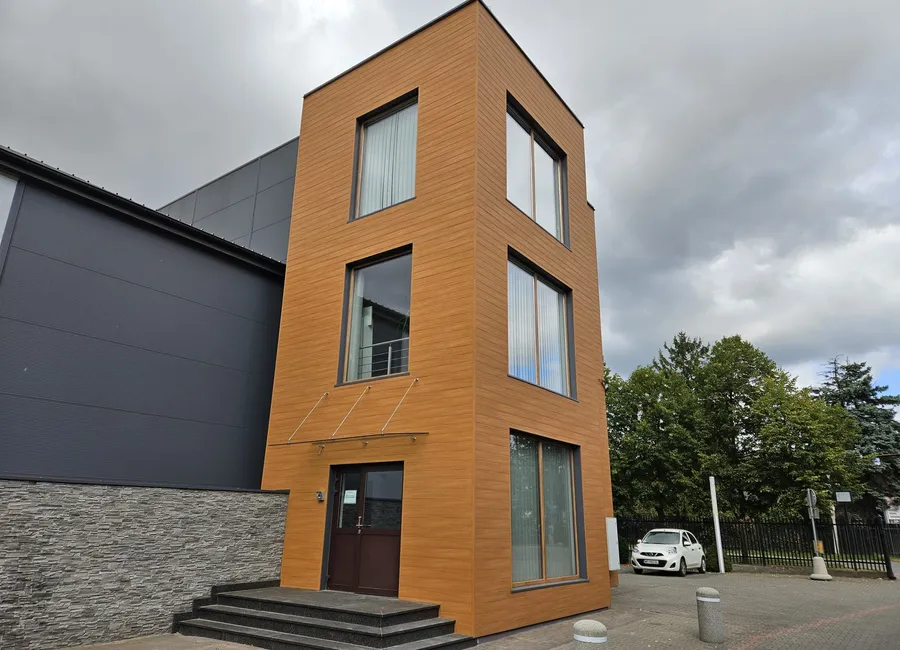 Budynek biurowy z klatką schodową obłożoną panelami aluminiowymi w dekorze drewna