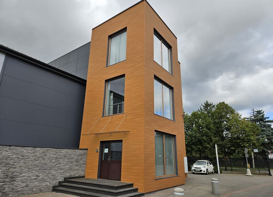 Budynek biurowy z klatką schodową obłożoną panelami aluminiowymi w dekorze drewna