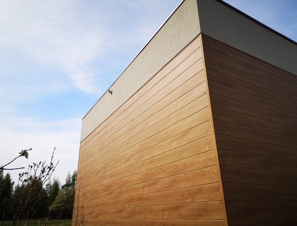 Ściana budynku obłożona panelami aluminiowymi w dekorze drewna