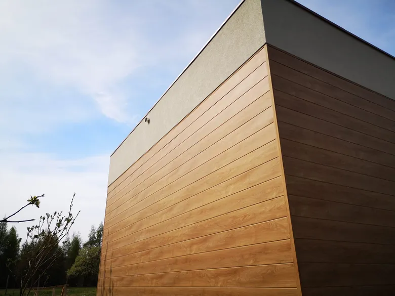 Ściana budynku obłożona panelami aluminiowymi w dekorze drewna