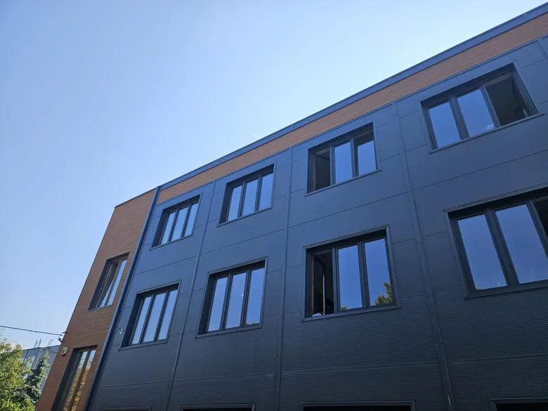 Biurowiec z grafitową elewacją aluminiową i drewnianym akcentem