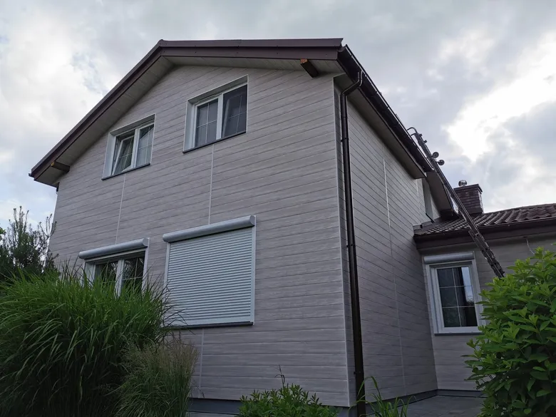 Dom jednorodzinny z szarą elewacją aluminiową o strukturze drewna