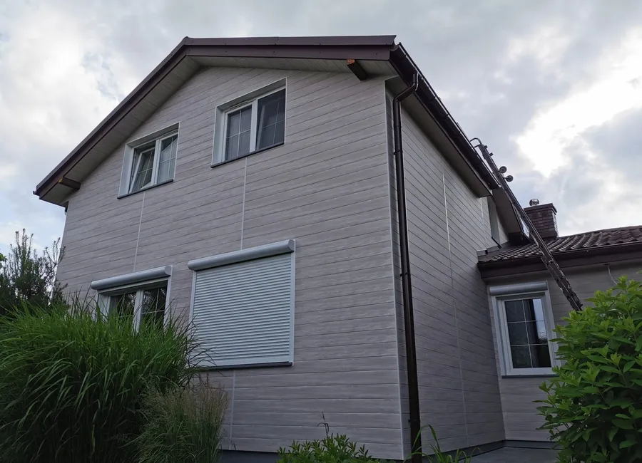 Dom jednorodzinny z szarą elewacją aluminiową o strukturze drewna