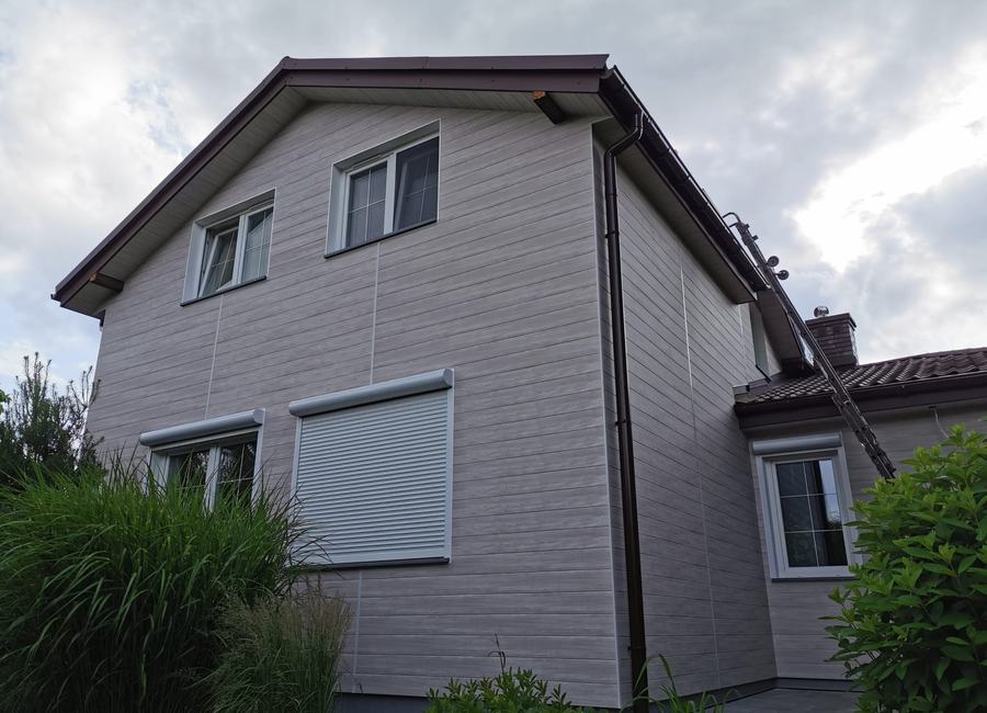 Dom jednorodzinny z szarą elewacją aluminiową o strukturze drewna